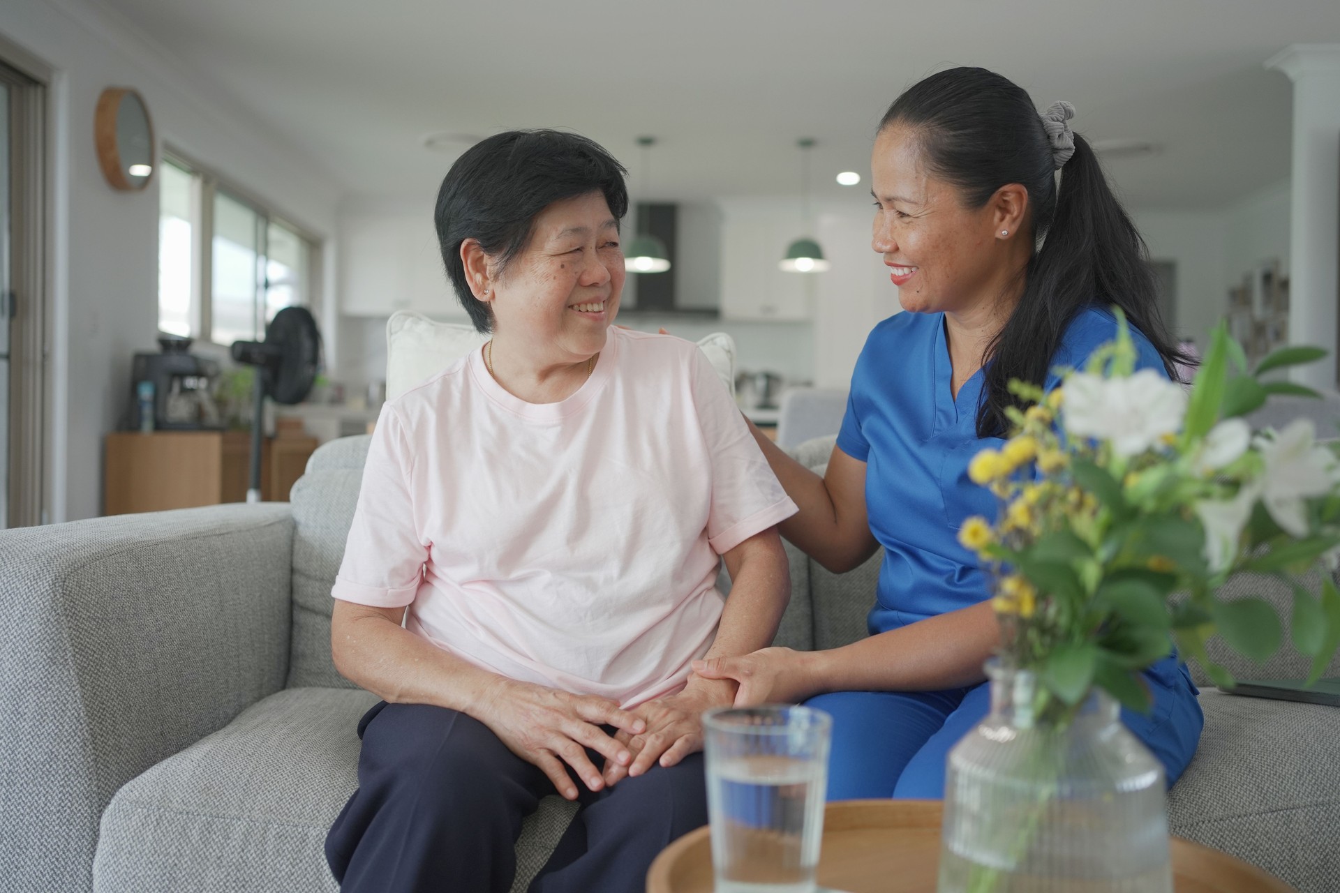 Asian health care worker visiting elderly woman at home, home nurse, home care service concept